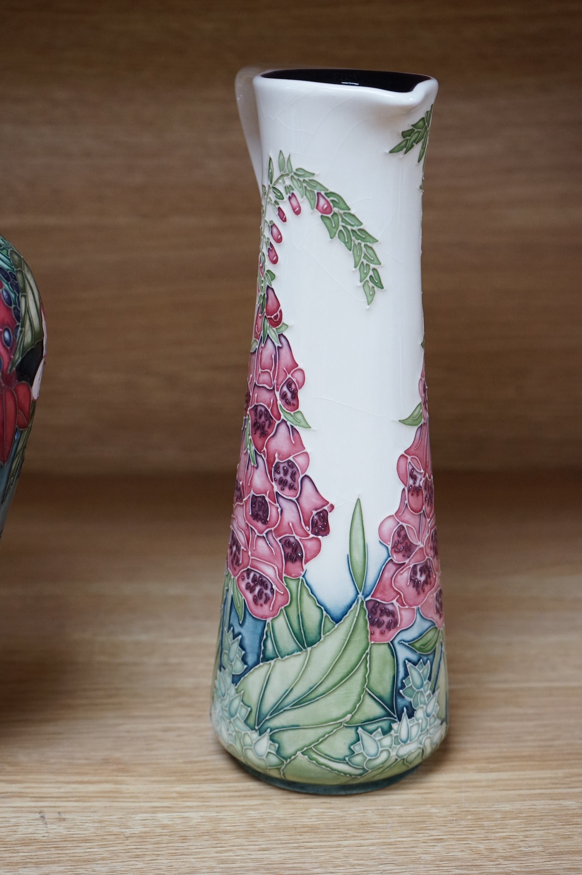 A Moorcroft ‘Nostalgia’ pattern vase together with a similar ‘Foxglove’ pattern ewer, 24.5cm. Condition - good, some crazing